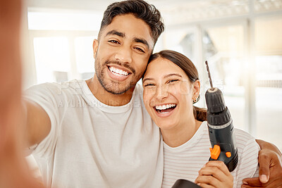 Buy stock photo Shot of a young couple standing together and taking a selfie while holding maintenance equipment at home