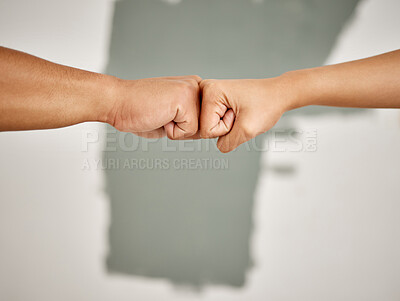 Buy stock photo Shot of an unrecognizable couple sharing a fist bump while painting at home