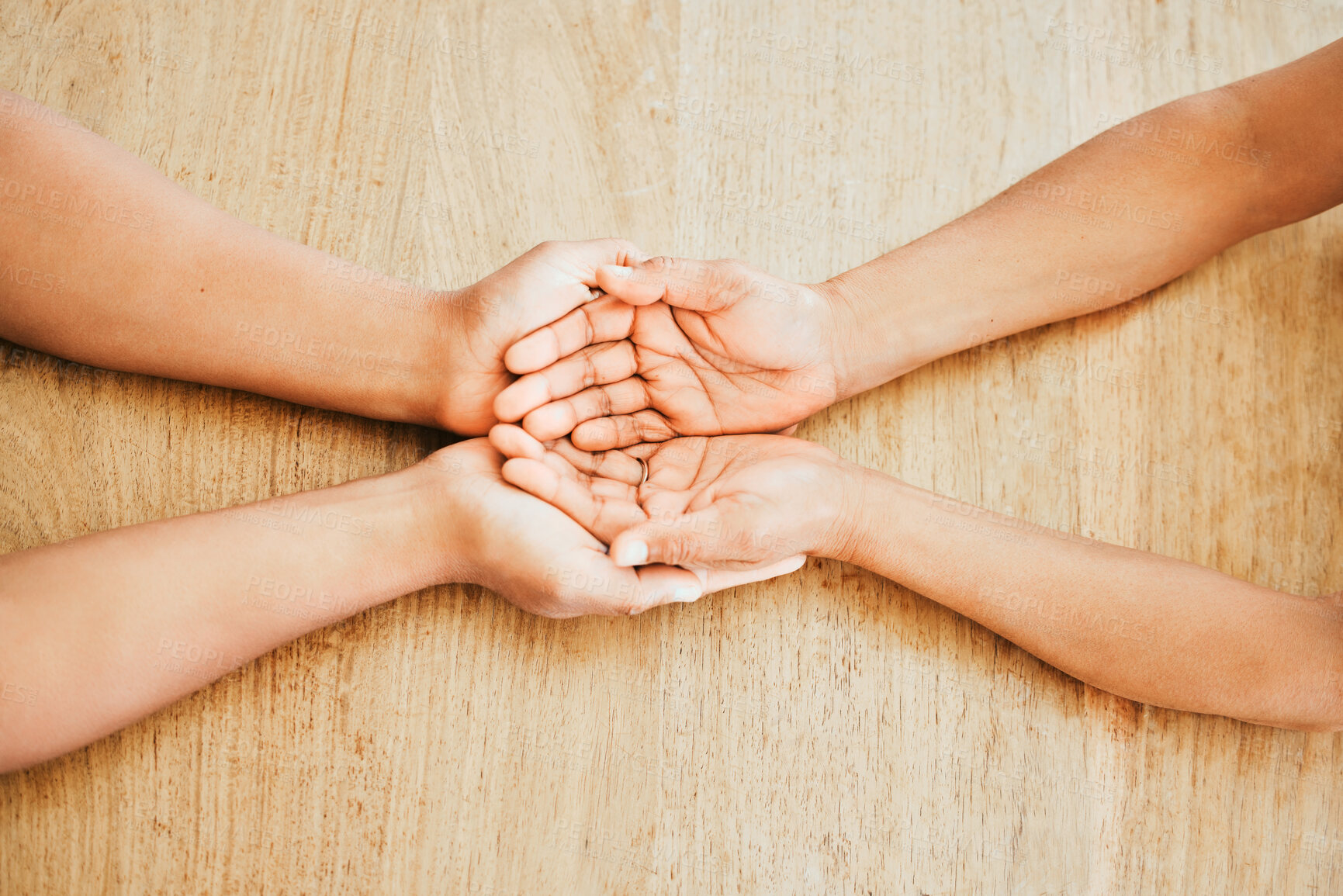 Buy stock photo Top view, couple and holding hands for support, love or trust with empathy on wooden table at home. Comfort, people or kindness for hope, care or connection together for marriage reconciliation above