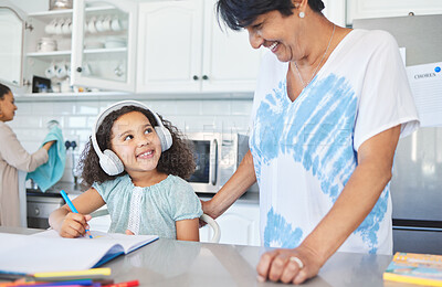 Buy stock photo Shot of a grandma helping her granddaughter at the kitchen table at home