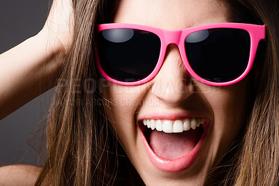 Buy stock photo Happy, sunglasses and portrait of woman in studio for fun, excited and crazy with confidence. Smile, face and female person with funky, fashion and stylish face accessory isolated by gray background.