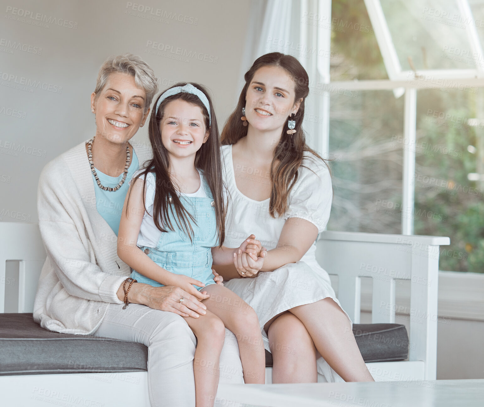 Buy stock photo Shot of a mature woman bonding with her daughter and granddaughter on the sofa at home