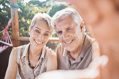 Buy stock photo Shot of a mature couple taking a selfie while sitting outside