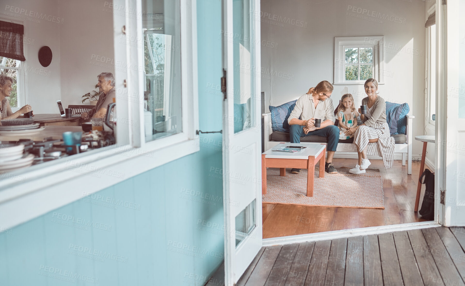 Buy stock photo Shot of a young couple and their daughter sitting together at home