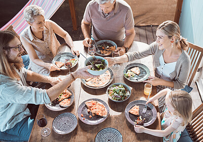 Buy stock photo High angle shot of a family sitting together and enjoying lunch