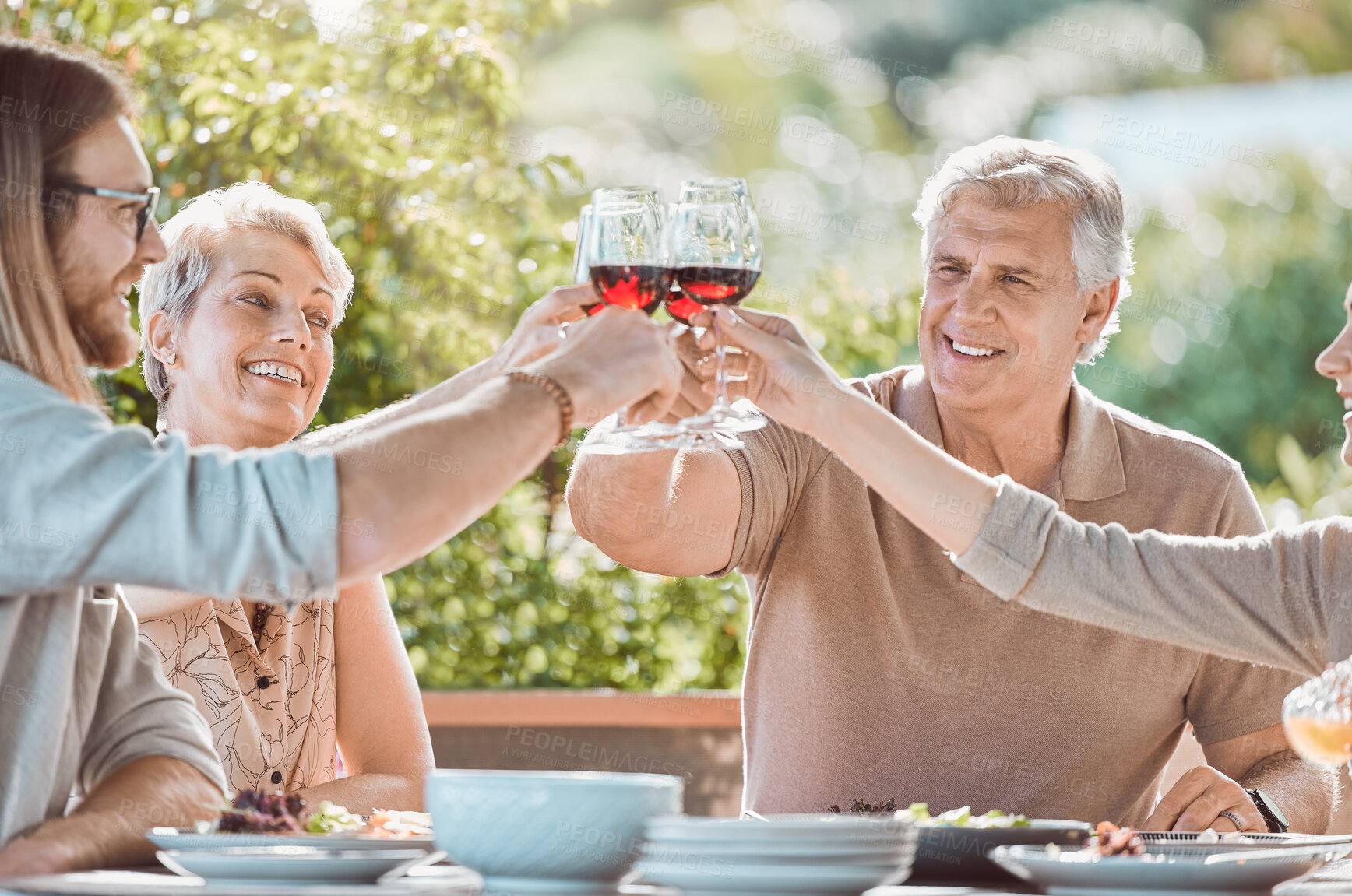 Buy stock photo Brunch, cheers and family sharing wine, smile and weekend gathering event at table on patio. Men, women and toast with glass, eating food together and happy dinner celebration on terrace at home