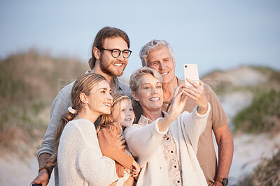 Buy stock photo Shot of a senior woman taking a selfie at the beach with her family