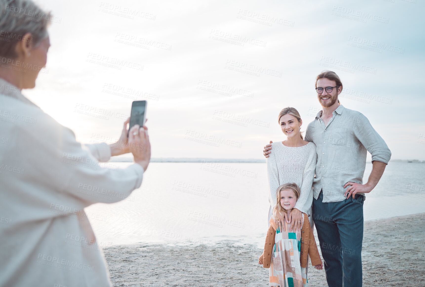 Buy stock photo Happy family, beach and picture with phone for photography or outdoor memory in Australia. Mother, father and daughter with smartphone camera for holiday, weekend or bonding moment by ocean coast