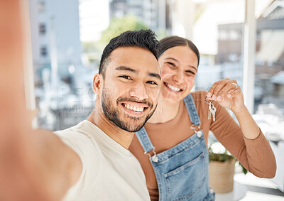 Buy stock photo Portrait of a young couple taking selfies while holding the keys to their new house