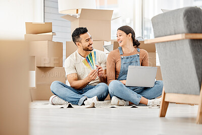 Buy stock photo Shot of a young couple using a laptop and going through colour swatches while moving house