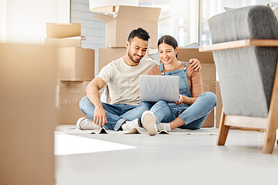 Buy stock photo Shot of a young couple using a laptop while moving house