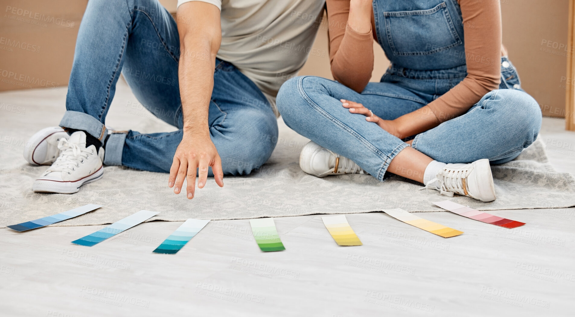 Buy stock photo Closeup shot of an unrecognisable couple going through colour swatches while moving house