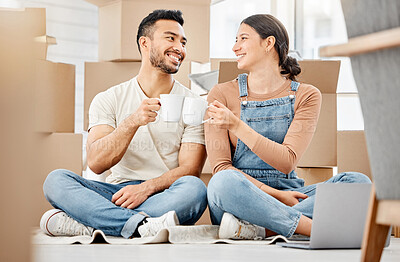 Buy stock photo Shot of a young couple sitting on the floor and drinking coffee while moving house
