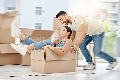 Buy stock photo Shot of a young couple playing with boxes while moving house