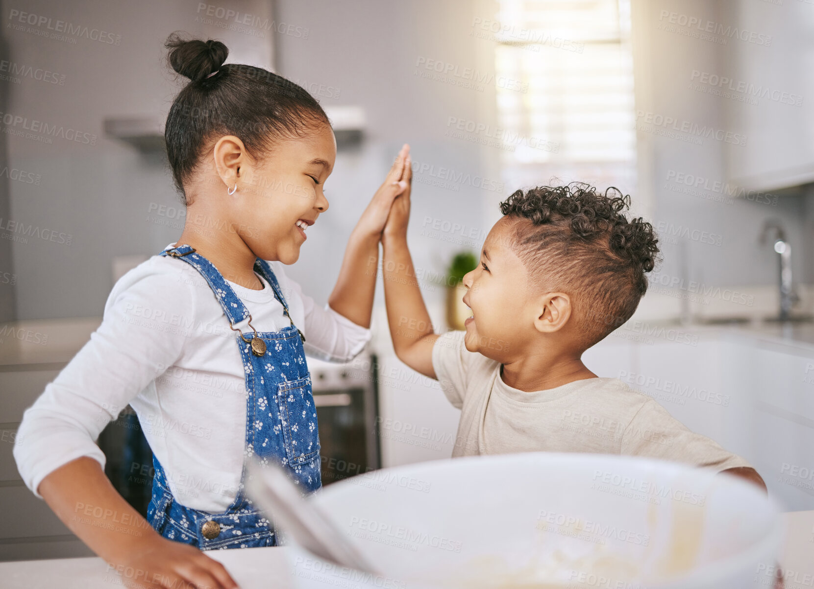 Buy stock photo Shot of a brother and giving a high five while baking in a kitchen