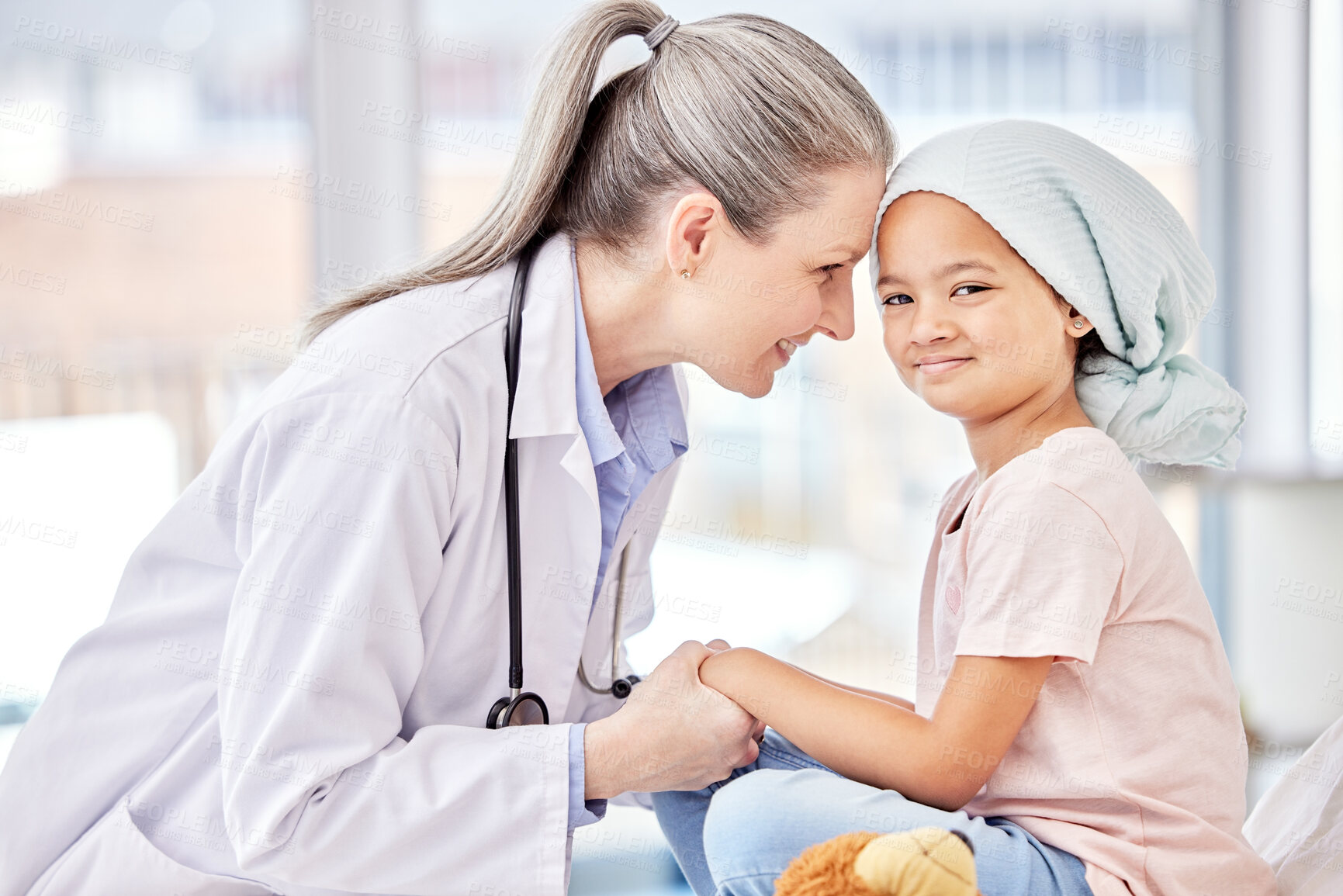 Buy stock photo Smile, pediatrician and child holding hands on bed in hospital for children, health and support in cancer treatment. Pediatrics, healthcare and happy kid, doctor with young patient for health care.