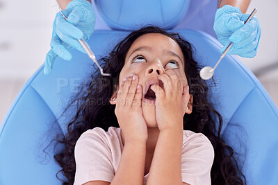 Buy stock photo Shot of a little girl looking shocked at the dentist