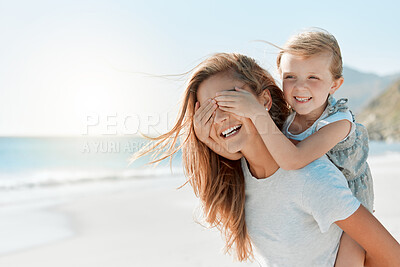 Buy stock photo Shot of a woman carrying her daughter on her back while at the beach