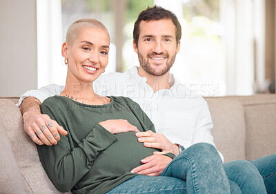 Buy stock photo Cropped portrait of an affectionate young expectant couple sitting on the sofa at home