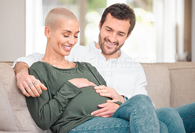 Buy stock photo Cropped shot of an affectionate young expectant couple sitting on the sofa at home