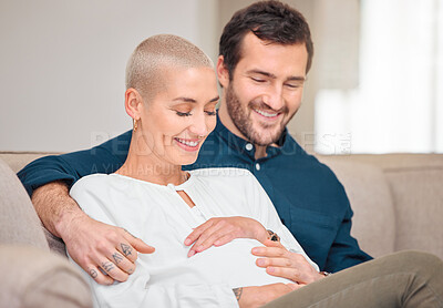 Buy stock photo Cropped shot of an affectionate young expectant couple sitting on the sofa at home