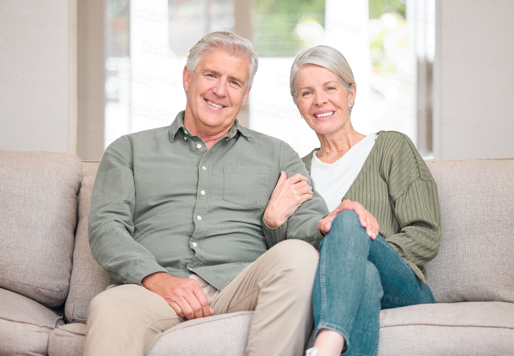 Buy stock photo Cropped portrait of an affectionate senior couple sitting on the sofa at home