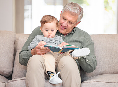 Buy stock photo Cropped shot of a handsome senior man reading to his grandson while sitting on the sofa at home