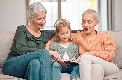Buy stock photo Shot of a mature woman bonding with her daughter and granddaughter while using a digital tablet