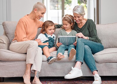 Buy stock photo Shot of a mature woman bonding with her daughter and grandkids while using a digital tablet