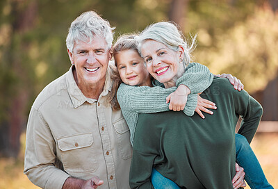 Buy stock photo Shot of a senior couple spending time outdoors with their granddaughter