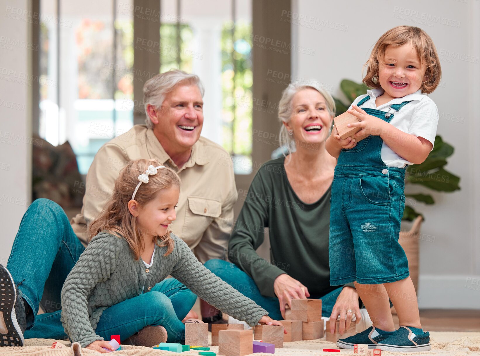 Buy stock photo Playing, children and grandparents in house, fun and bonding of family, growth and development in lounge. Games, kids and learning with wooden blocks, people and smile in living room, floor and home