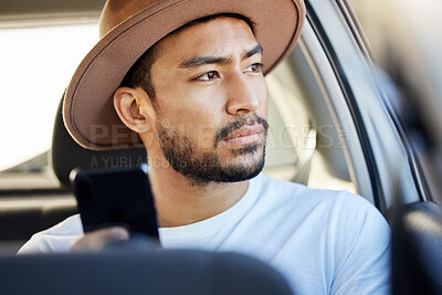 Buy stock photo Shot of a young man sitting in a car while using his phone
