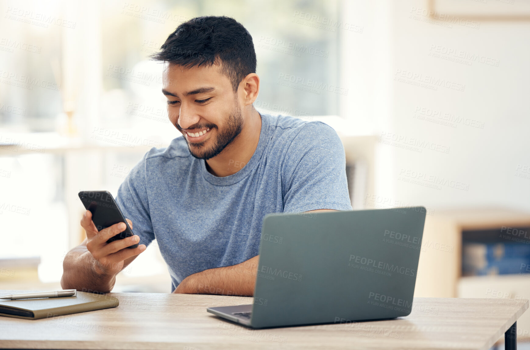 Buy stock photo Shot of a young businessman using a phone in an office at work