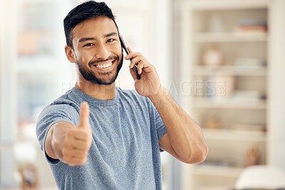 Buy stock photo Shot of a young businessman showing a thumbs up while on a call at home