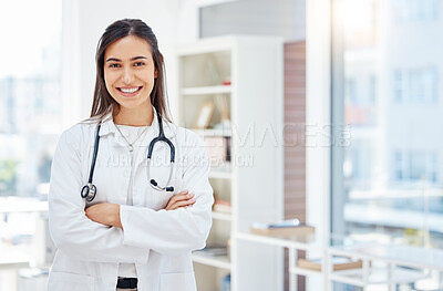 Buy stock photo Shot of a young female doctor standing with her arms crossed in her office at a hospital