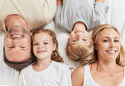 Buy stock photo Shot of a beautiful young family bonding in bed together
