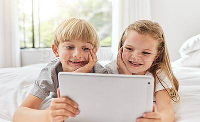 Buy stock photo Shot of a brother and sister using a tablet together in bed