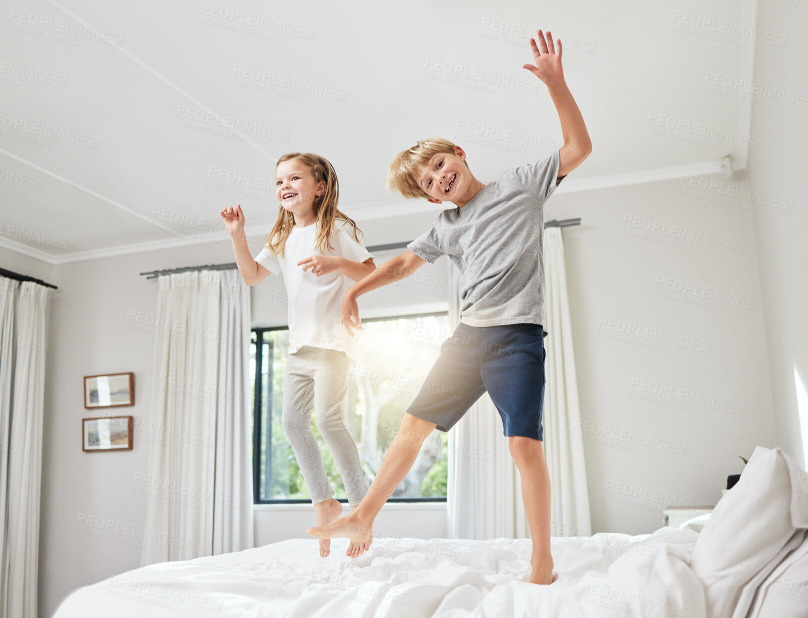 Buy stock photo Happy kids, playing or jump with sibling on bed for fun weekend, bonding or playful holiday at home. Little boy, girl or children enjoying activity in air for joy or entertainment together in bedroom