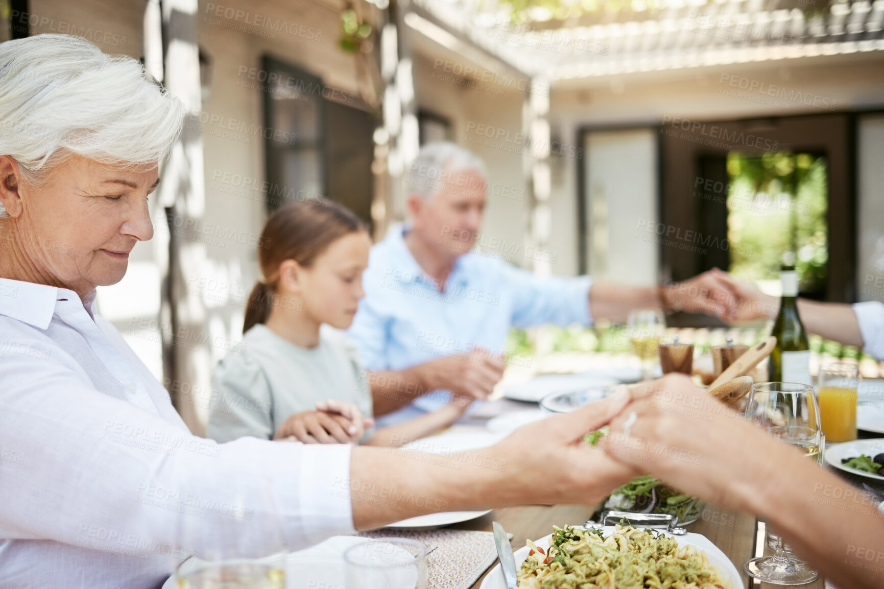 Buy stock photo Shot of a family saying grace while sitting together at the dining table