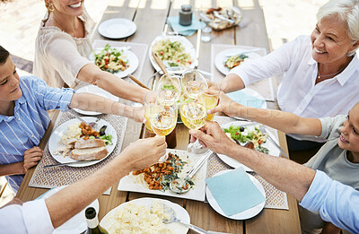 Buy stock photo Shot of a family sharing a toast while enjoying a meal together