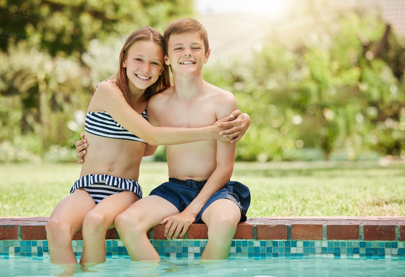 Buy stock photo Shot of a young boy and girl sitting with their feet in the pool