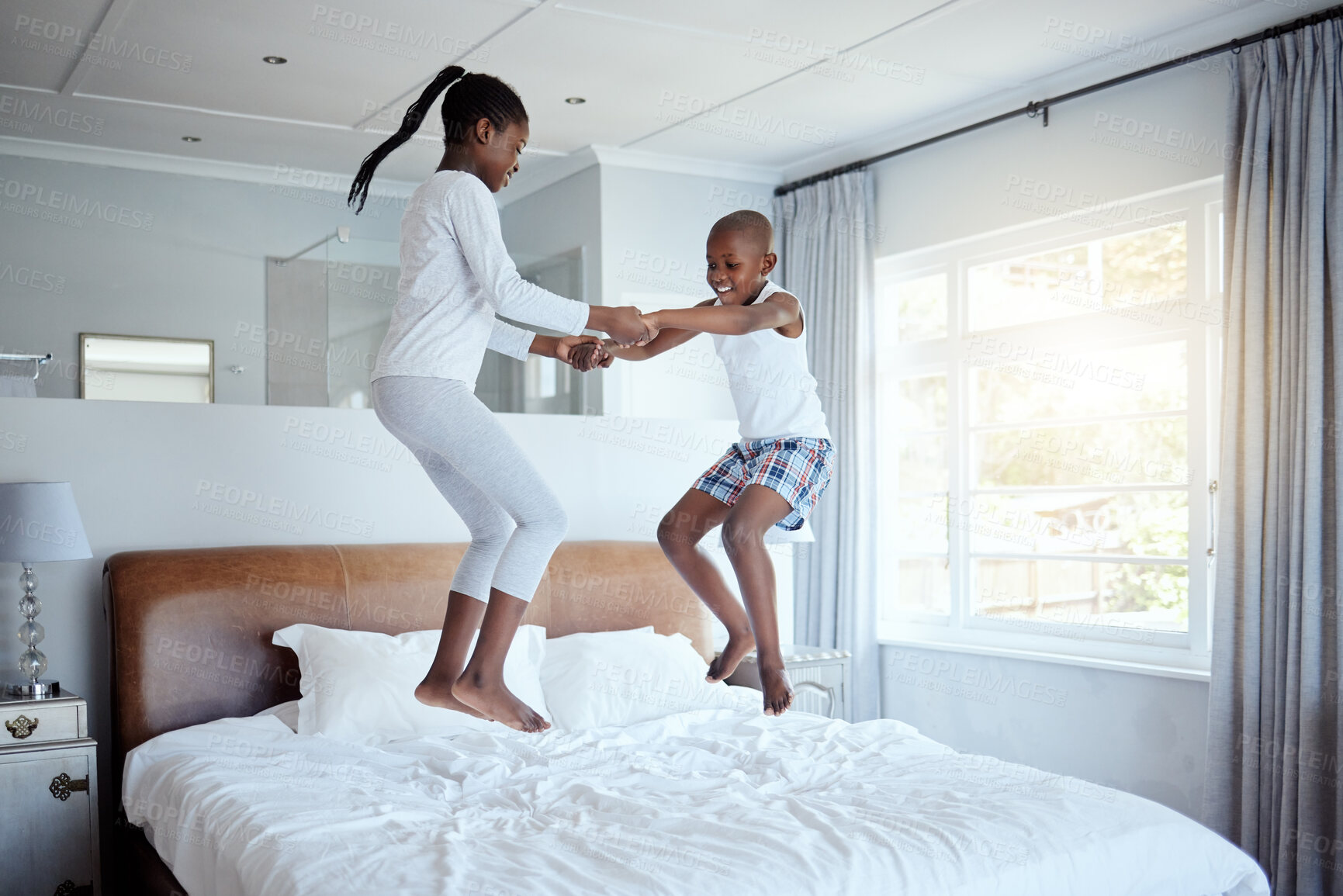 Buy stock photo Happy African kids, morning and jump on bed in home for playing, celebration and boy dance with girl. Children, energy and bounce in bedroom for game, family fun and brother holding hands with sister