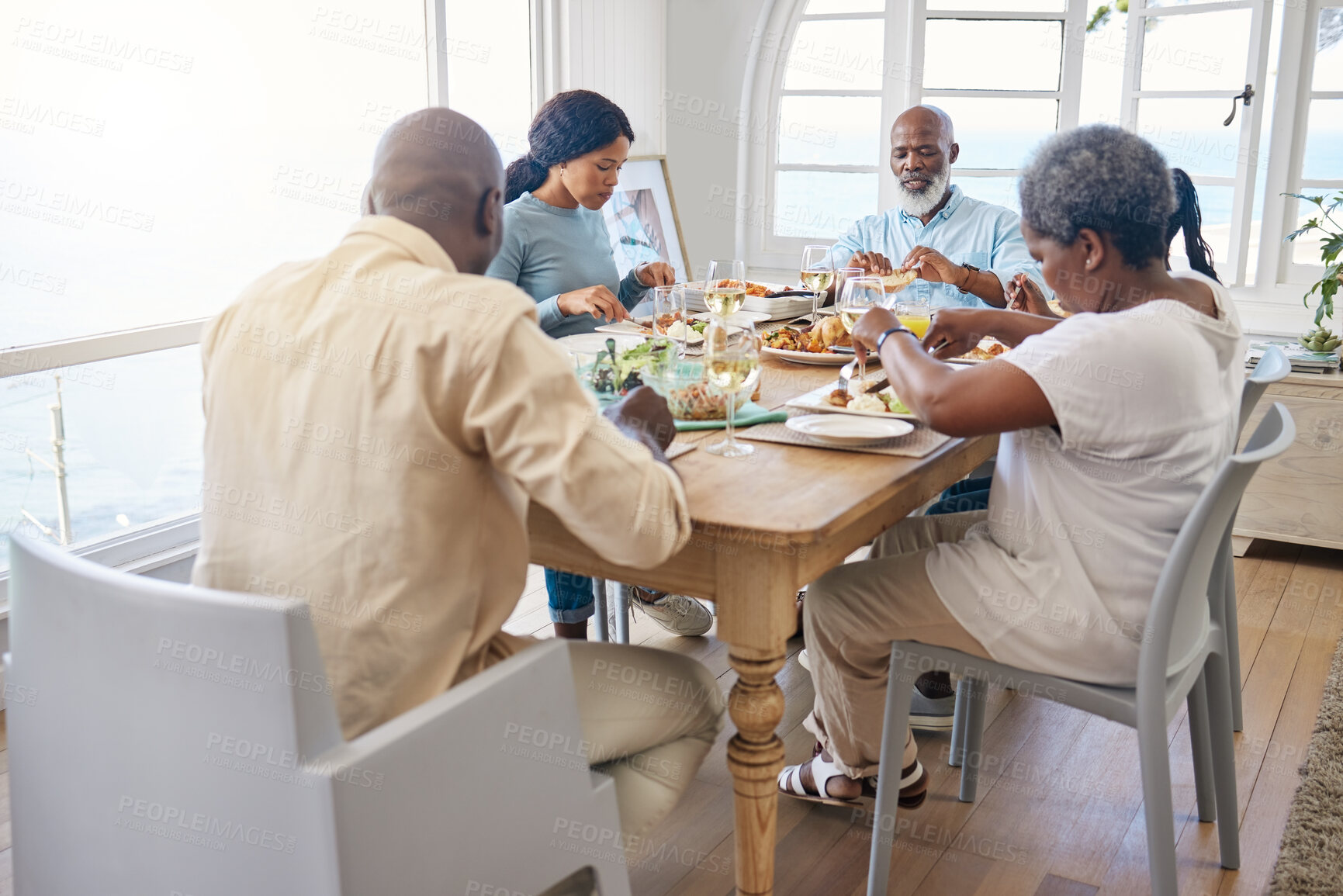 Buy stock photo Eating, group and food with black family in home for Thanksgiving celebration, festive holiday and brunch. Support, love and party with people and lunch for nutrition, grateful and tradition event