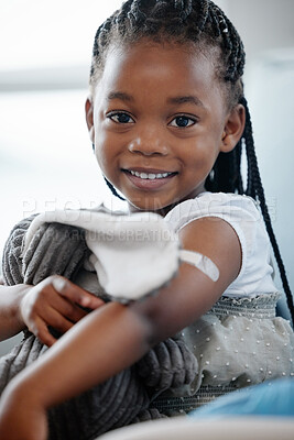 Buy stock photo African girl kid, vaccine and portrait with smile, medicine or happiness on sofa for wellness in hospital. Female child, happy or excited with plaster for injection, healthcare or brave to stop virus
