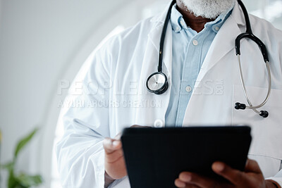 Buy stock photo Closeup shot of an unrecognisable doctor using a digital tablet in a medical office