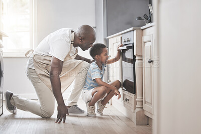 Buy stock photo Shot of a father and son standing by the oven in the kitchen