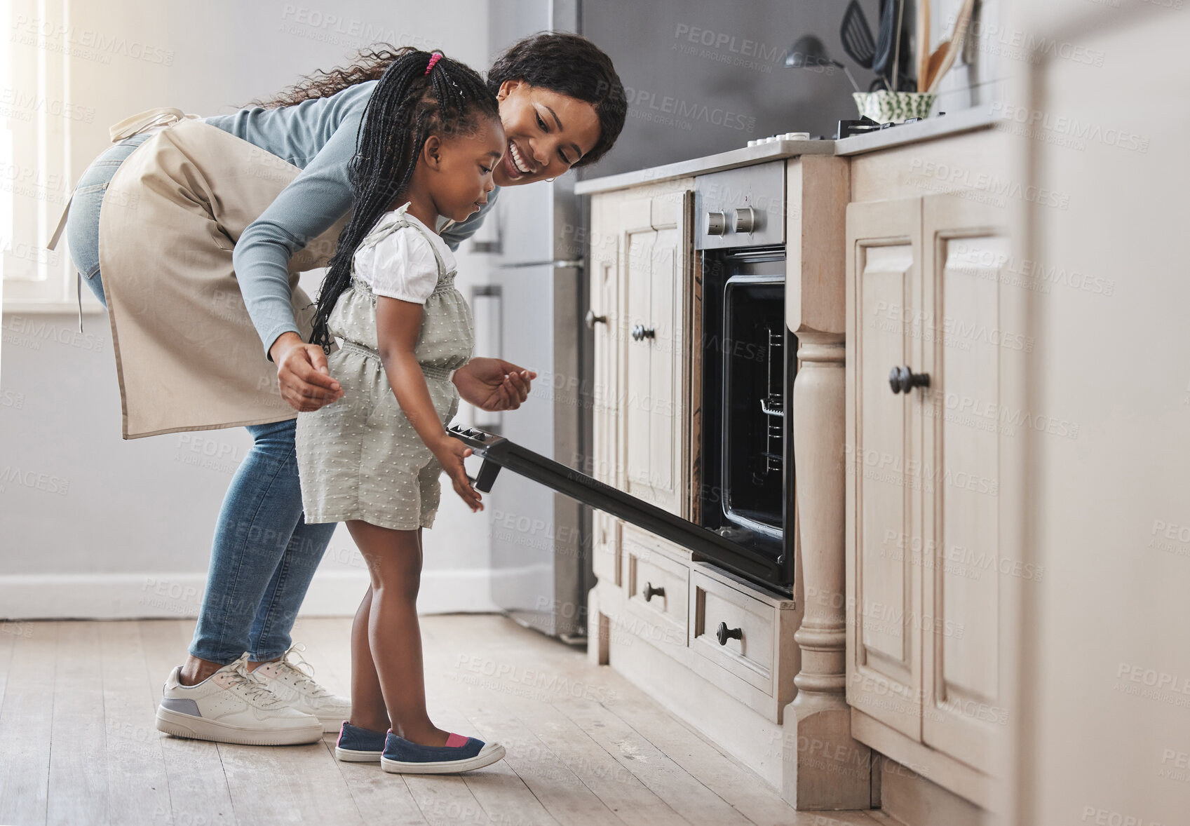 Buy stock photo Baking, cooking in oven and mother with daughter in home kitchen together for development. Help, love and smile of black family in apartment with single parent woman teaching girl child how to bake