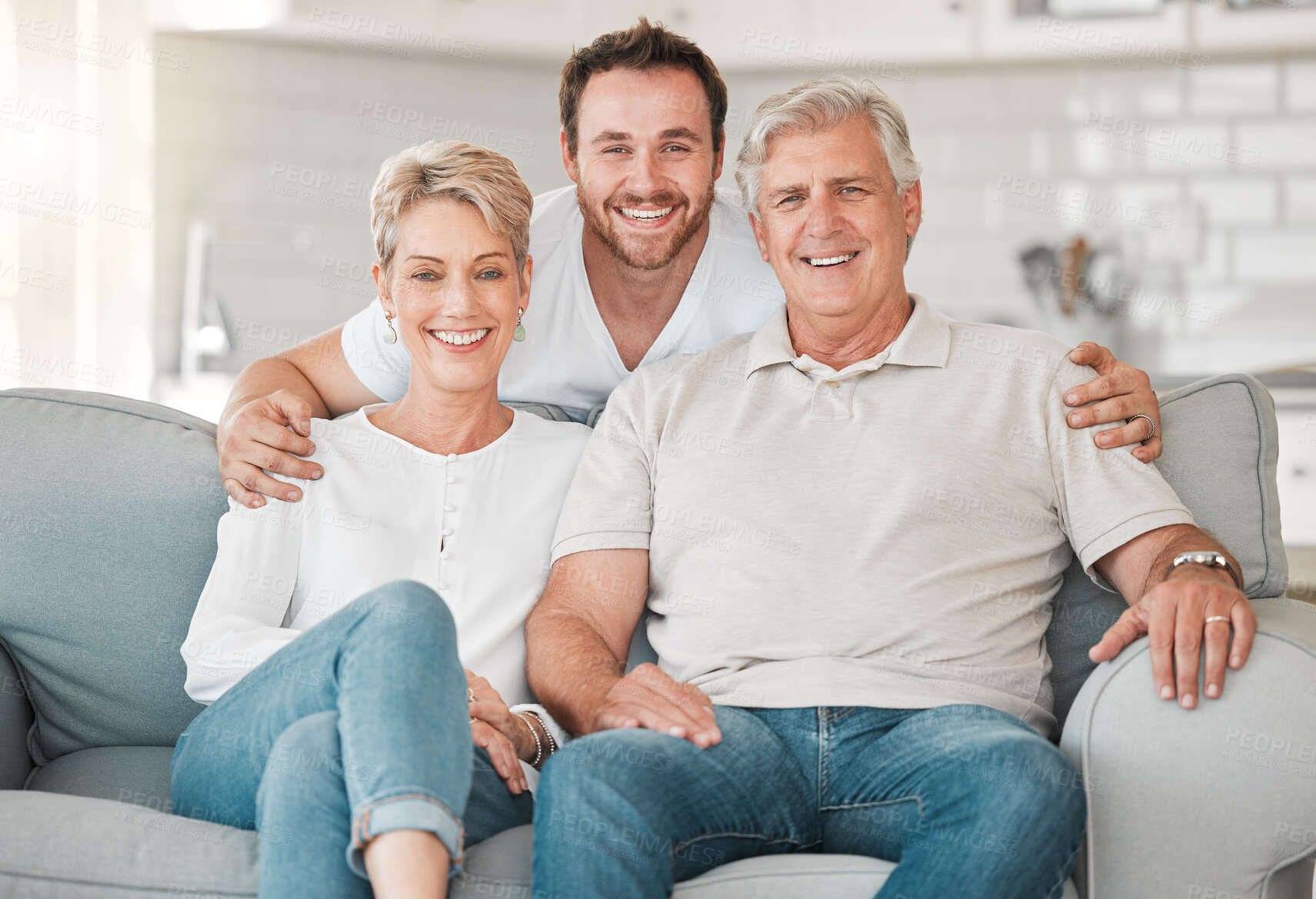 Buy stock photo Portrait, senior parents and man on sofa for love, connection and bonding together with hug in home. Happy family, mother and father with adult son for relationship, support and security in house