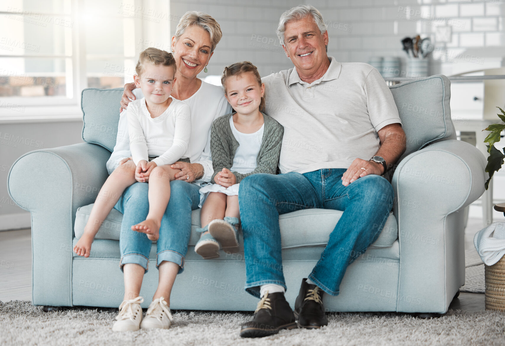 Buy stock photo Shot of a happy senior couple and their granddaughters  relaxing on the sofa at home