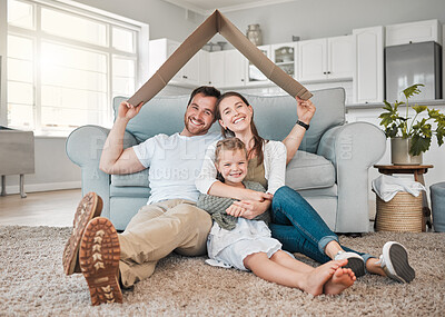 Buy stock photo Portrait of a young family sitting on the lounge floor under a cardboard fort together at home